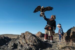 Eagle roosting on Mongolian man's hand