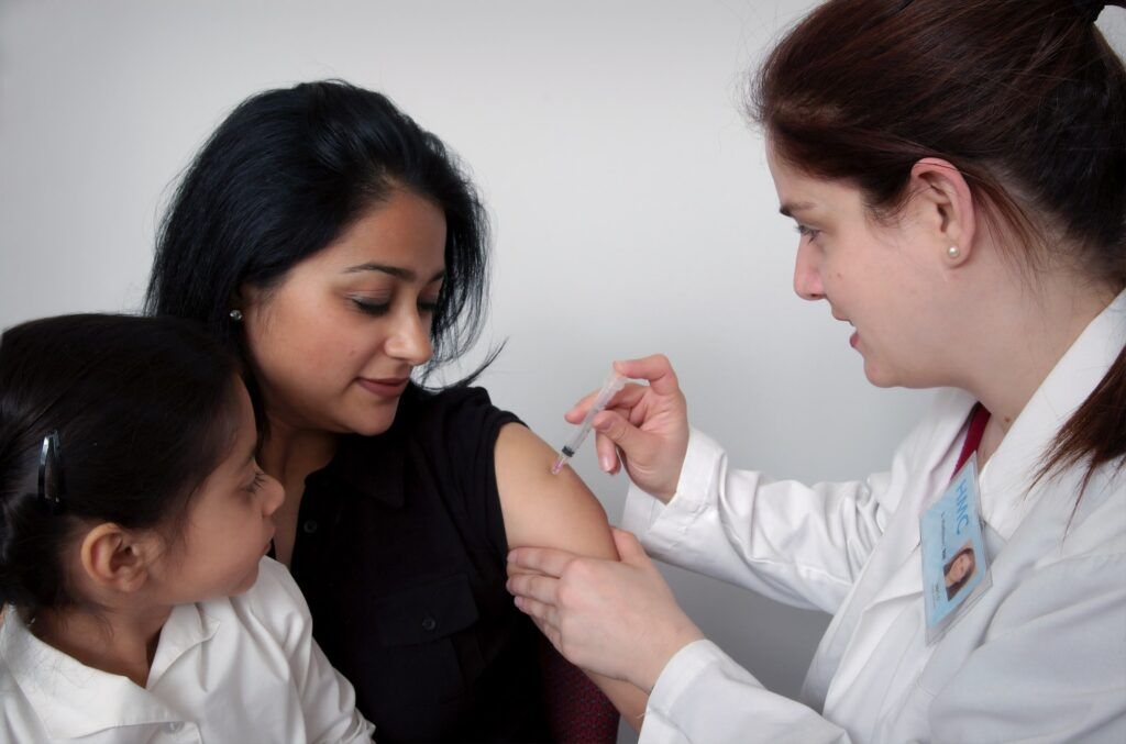 woman receiving a jab from a lady doctor